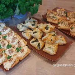 Pyszne przekąski na szybko: kruche ciasteczka z pastą serową i orzechami, a obok pieczone rogaliki ze szpinakiem i inne wypieki.