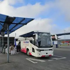 Autobus Aerobus z napisem "Paris-Beauvais" czeka na pasażerów pod niebieskim zadaszeniem.
