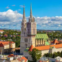 Zagrzeb co zobaczyć: majestatyczna katedra z dwiema wieżami góruje nad miastem, otoczona zabytkową architekturą i zielenią.