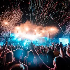 Konfetti regnet auf ein jubelndes Publikum bei einem Festival. Die Bühne ist hell beleuchtet, die Stimmung ist ausgelassen: ab geht die Lutzi!