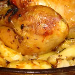 Un plat de poulet au four avec des pommes de terre dorées et juteuses, prêt à être dégusté.
