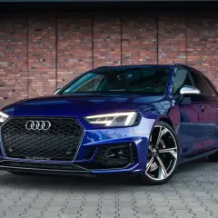 Błękitne Audi RS4 Avant z charakterystycznym grillem i felgami, gotowe na każdą drogę.