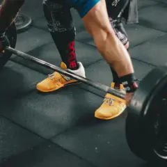 Siłacz przygotowuje się do podniesienia sztangi. Czy crossfit jest tego wart? Intensywny trening, który buduje siłę i wytrzymałość.