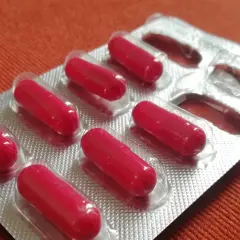 Czerwone kapsułki w blistrze. Może to suplement diety, np. cynk na co dzień, dla wzmocnienia odporności.
