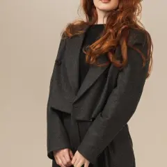 Elegancki komplet spodnie z tuniką w ciemnoszarym kolorze. Modelka ma rude włosy.