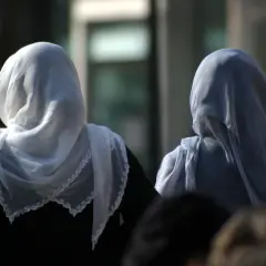 Dwie kobiety w hidżabach, symbolizujące tradycję i to, czego nie wolno kobietom w Turcji, idą ulicą.