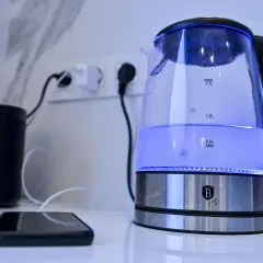 Ein beleuchteter Wasserkocher steht neben einem Smartphone. Ein Tipp: Wasserkocher entkalken Backpulver hilft gegen Kalk.