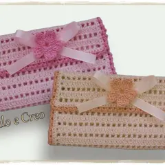 Due pochette porta trucchi uncinetto, rosa e beige, decorate con fiorellini e nastri.