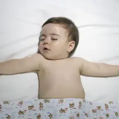 Śpiące dziecko z rozłożonymi rączkami. Choć obrazek nie sugeruje zespołu Turnera, warto pamiętać o jego istnieniu.