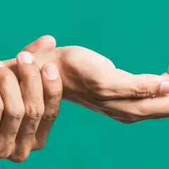 Mano che si tiene il polso, indicando dolore o fastidio, forse legato all'artrite polso.