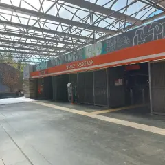 Ingresso della stazione **Valle Aurelia** a Roma, con tettoia metallica e graffiti.