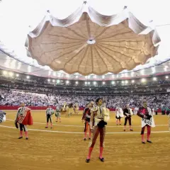 Toreros listos en una de las plazas de toros cubiertas en España, con público en las gradas y un techo desplegable.