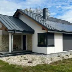 Nowy, nowoczesny dom z panelami słonecznymi na dachu. Zgłoszenie zakończenia budowy czeka na odbiór.