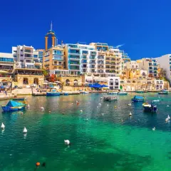 Malta, St Julian's: malowniczy port z turkusową wodą, łodziami i nowoczesnymi budynkami.