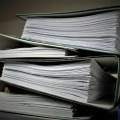 Stosy dokumentów w segregatorach. Szukasz informacji, jak znaleźć numer księgi wieczystej?
