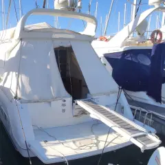 Il Raffaelli Typhoon, un lussuoso yacht bianco, è ormeggiato in un porto. La passerella è estesa, pronta per l'imbarco.