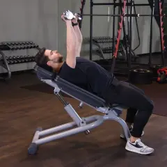 Mężczyzna wykonuje ćwiczenie incline dumbbell press na ławce skośnej, podnosząc ciężarki nad klatkę piersiową.