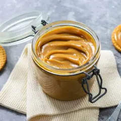 Un vasetto pieno di cremoso dulce de leche, pronto per essere spalmato su biscotti croccanti.