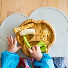 Dziecko wybiera jaki makaron dla niemowlaka z talerzyka w kształcie chmurki. Na talerzyku są też banan, ogórek i paluszki.