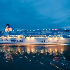Prom Silja Line Galaxy płynie po wodzie, odbijając światła. Podróż z Rygi do Helsinek nocą.