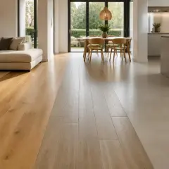 Un soggiorno moderno con pavimenti in legno e resina che si incontrano, creando un contrasto elegante. La resina, materiale versatile, dona un tocco contemporaneo.