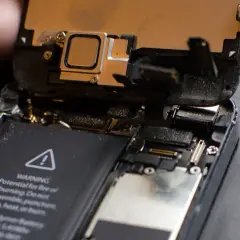 Odkryty telefon, bateria i głośnik. Może to być pomocne, gdy zastanawiasz się, jak zresetować głośnik w telefonie.