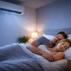 Couple dormant paisiblement sous la climatisation. La question "a combien mettre la clim dans une chambre" est résolue pour un sommeil parfait.