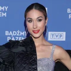 Ida Nowakowska w błyszczącej kreacji i czarnej, pikowanej marynarce na tle niebieskiego baneru z napisem "Bądźmy razem".