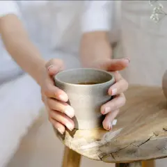 Sanfte Hände halten eine Tasse Brennnesseltee. Ob morgens oder abends, dieser Tee ist ein Genuss.