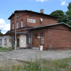 Stary ceglany budynek dworca kolejowego Golina z napisem "GOLINA" na fasadzie.