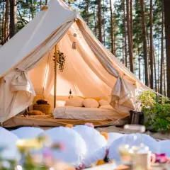 Przytulny namiot w lesie, idealny na glamping noclegi. Wygodne łóżko, dekoracje i atmosfera relaksu.