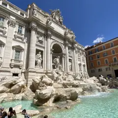 Fontaine de Trevi, un chef-d'œuvre baroque à Rome, Italie, avec des touristes admirant sa splendeur sous un ciel bleu.