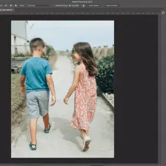 Two children, a boy and a girl, are walking away from the camera. The image is being edited in Photoshop, with a selection tool active, indicating a cut out process.