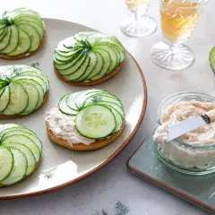 Délicieuses tartelettes salées gastronomiques ornées de fines rondelles de concombre disposées en spirale, garnies d'une touche d'aneth.