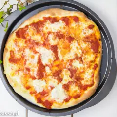 Pyszna pizza na miękkim cieście, z sosem pomidorowym i ciągnącym się serem, gotowa do podania.
