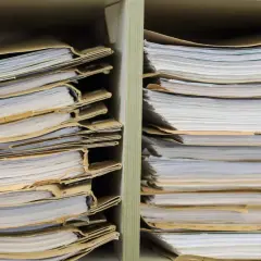 Stosy akt w segregatorach. Szukasz informacji, jak sprawdzić numer sprawy na policji? Te dokumenty mogą zawierać odpowiedź.
