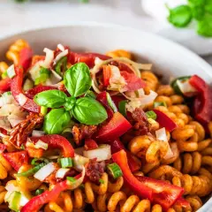 Kolorowa, najlepsza sałatka z makaronem fusilli z papryką, pomidorami suszonymi, cebulą i bazylią.