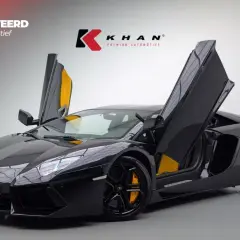 Czarny Lamborghini Aventador z otwartymi drzwiami, żółte akcenty we wnętrzu.