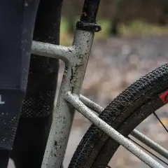 Błotnista szytka rowerowa z widoczną torbą "RYSEL" i oponą z bieżnikiem.
