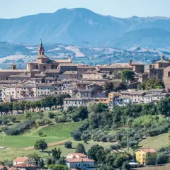 Panoramica di Corinaldo, borgo medievale nelle Marche, con le sue case in pietra e le colline verdi circostanti.
