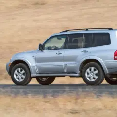 Mitsubishi Montero 3.2 DID off road, plate VM 5666, driving on a dusty road with dry grass background.