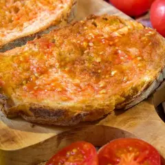 Rebanadas de pan tostado con tomate rallado y aceite de oliva, un delicioso pan de tomate listo para disfrutar.