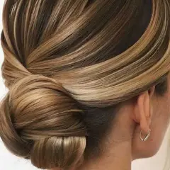 Acconciature capelli medi per cerimonia: un elegante semiraccolto con morbide onde e un chignon basso, perfetto per un look sofisticato.