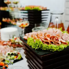 Bogaty bufet z wędlinami, sałatkami i napojami. Zastanawiasz się, ile kosztuje catering firmowy?