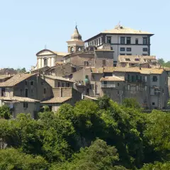 Borgo medievale di Gradoli, affacciato sul lago di Bolsena, con case in pietra e una chiesa con campanile.