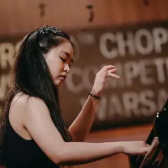 Młoda pianistka gra na fortepianie podczas konkursów chopinowskich.