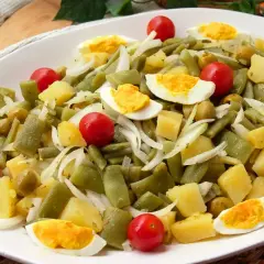 Deliciosa ensalada de judías verdes con patatas, huevo duro, tomates cherry y aceitunas. Un plato fresco y nutritivo.