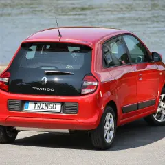 Czerwone renault twingo 3 z czarną klapą bagażnika stoi nad jeziorem.