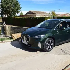 Un BMW Serie 2 Active Tourer verde oscuro aparcado cerca de una esclusa de agua. ¿Problemas con el coche o solo una parada escénica?