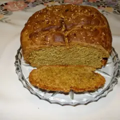 Pyszny, domowy chleb pytlowy z ziarnami na wierzchu, pokrojony na talerzyku.